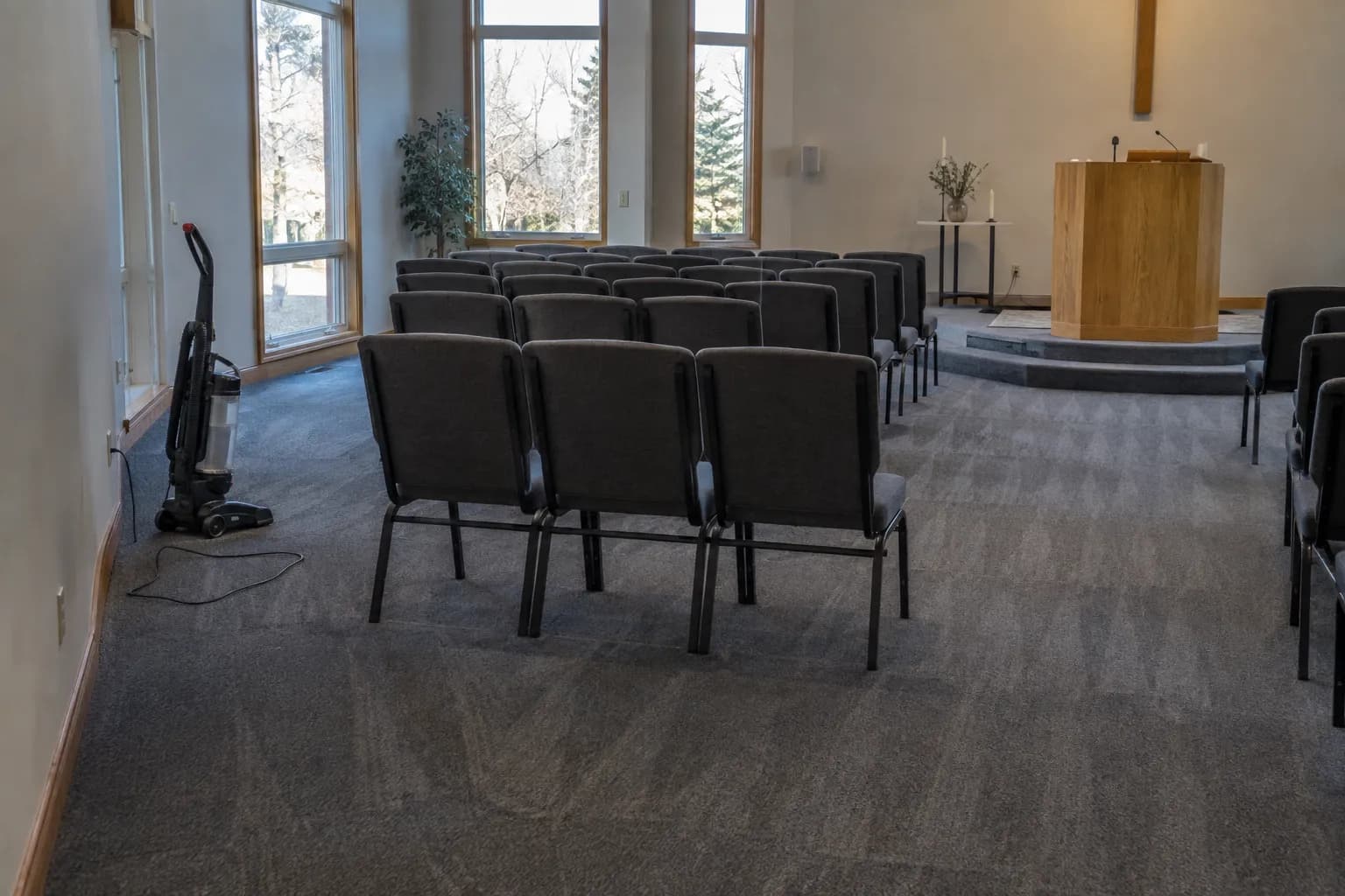 Rows of chairs in a church worship space with fresh vacuum lines on the carpet