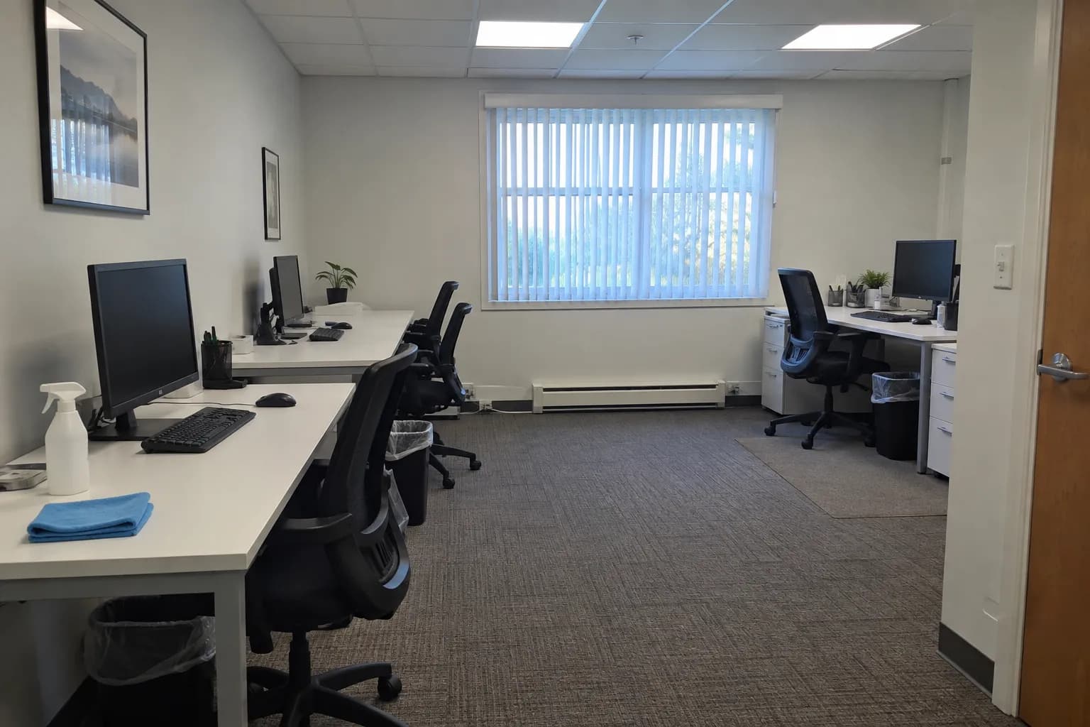 Small office suite after the daily cleaning, with desks wiped and fresh trash liners